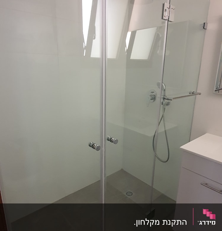 מקלחון זכוכית עם דלתות ומקלחת יד